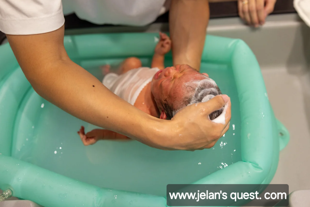 supports-a-newborn’s-head-while-washing-the-baby’s-hair-during-a-bath-in-a-small-tub-showing- proper-newborn- bathing-care