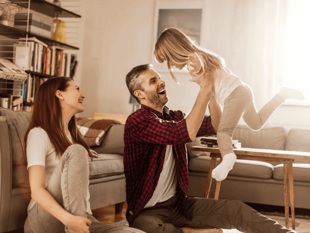 Parents-enjoying-time-with-their-joyful-toddler--highlighting-a-nurturing-family-bond