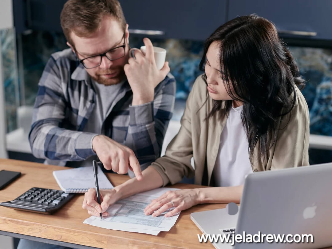 Couple-sitting-at-a-table-planning-finances-and-life-goals-with-a-laptop-notebook-and-calculator.