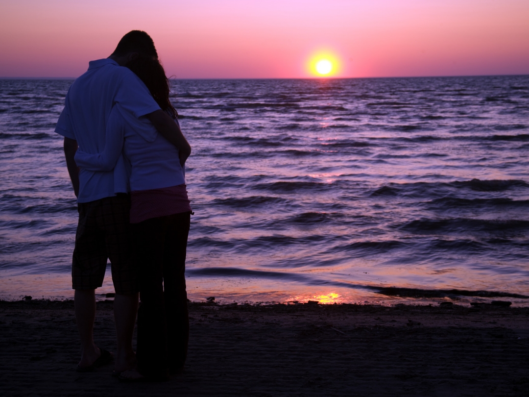 Couple-watching-sunset-leaning-on-each-other