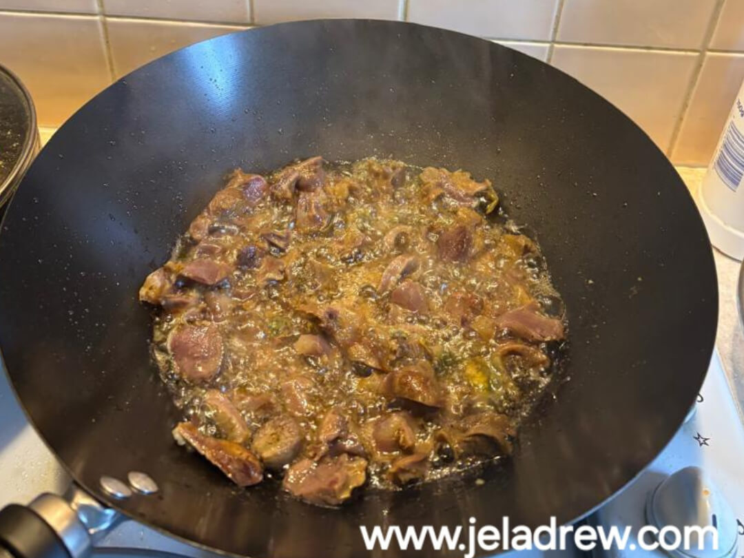 Close-up-of-seasoned-chicken-gizzards-turning-golden-brown-while-frying-in-a-pan-crispy-and-sizzling. 