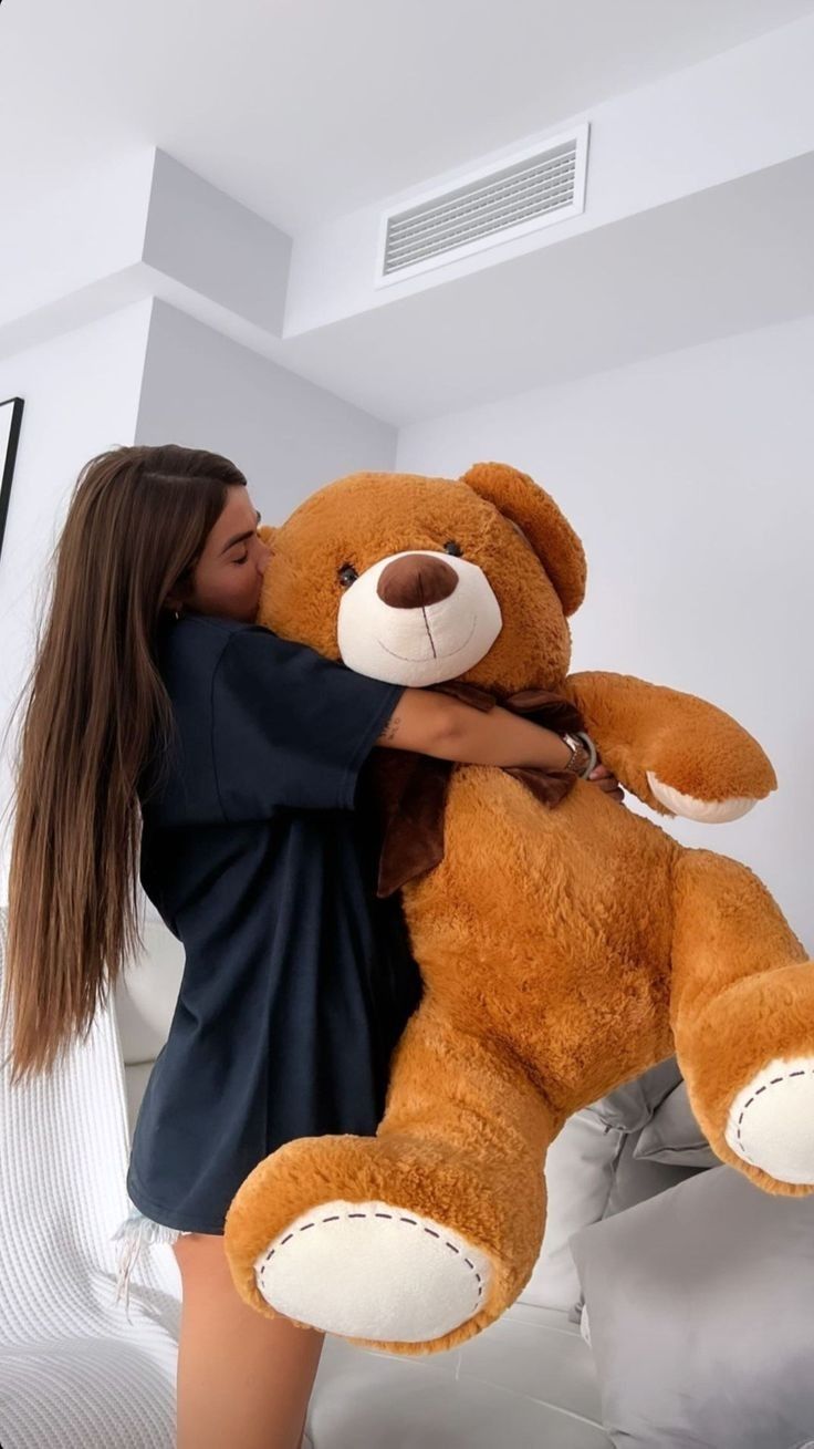 Teen-girl-hugging-giant-teddy-bear.