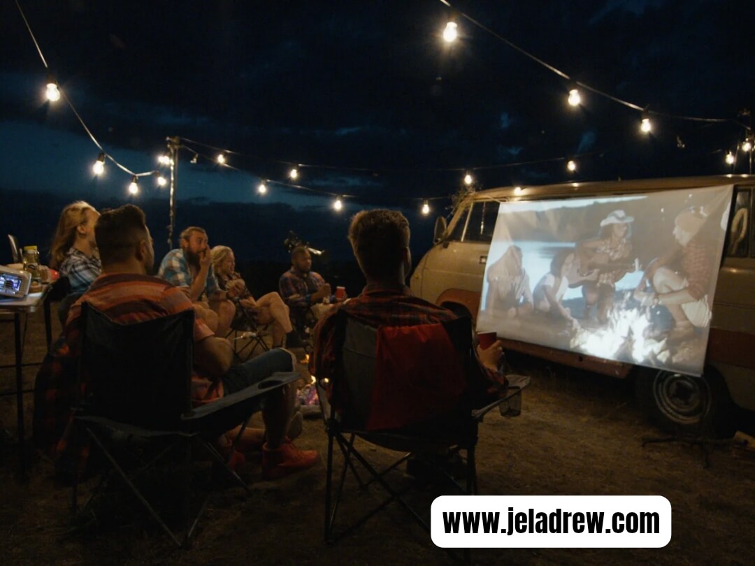 Family-and-friends-enjoying-an-out-door-movie-night-under-string-lights.