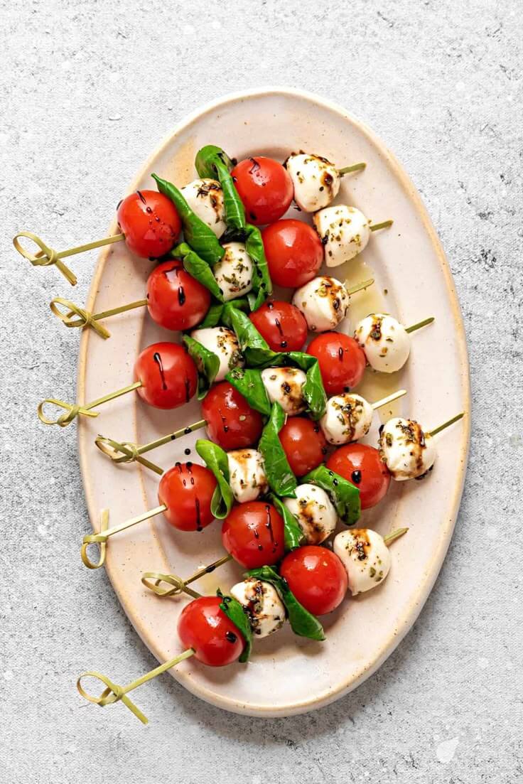 Caprese-skewers-with-cherry-tomatoes-mozzarella-balls-and-fresh-basil-on-a-platter