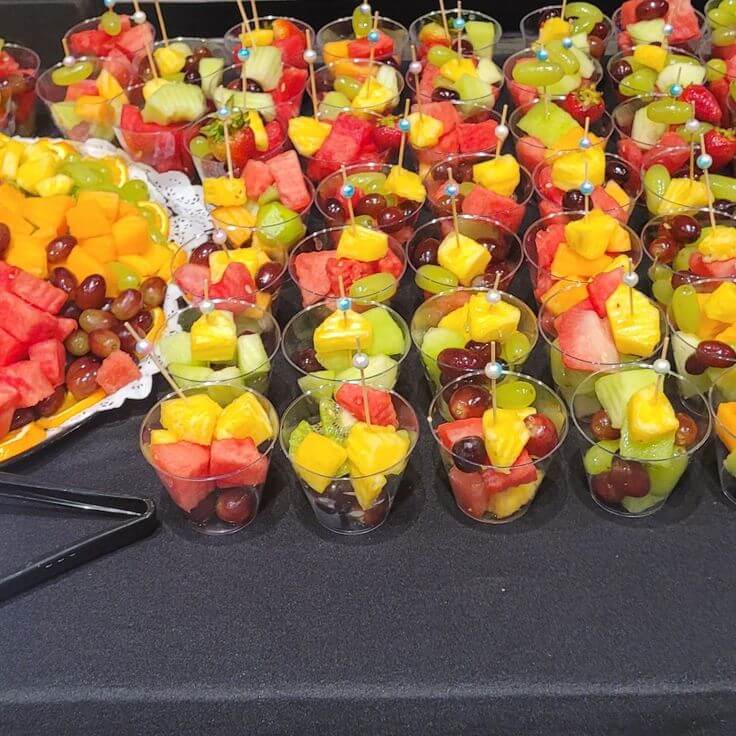 Individual-fruit-cups-layered-with-colorful-mixed-fruits-in-clear containers.