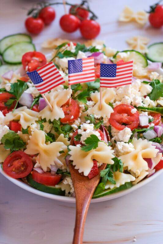 Patriotic-pasta-salad-with-bowtie-pasta-tomatoes-cheese-and-mini-American-flags-15-ddelicious-4th-of-jJuly-side-dishes