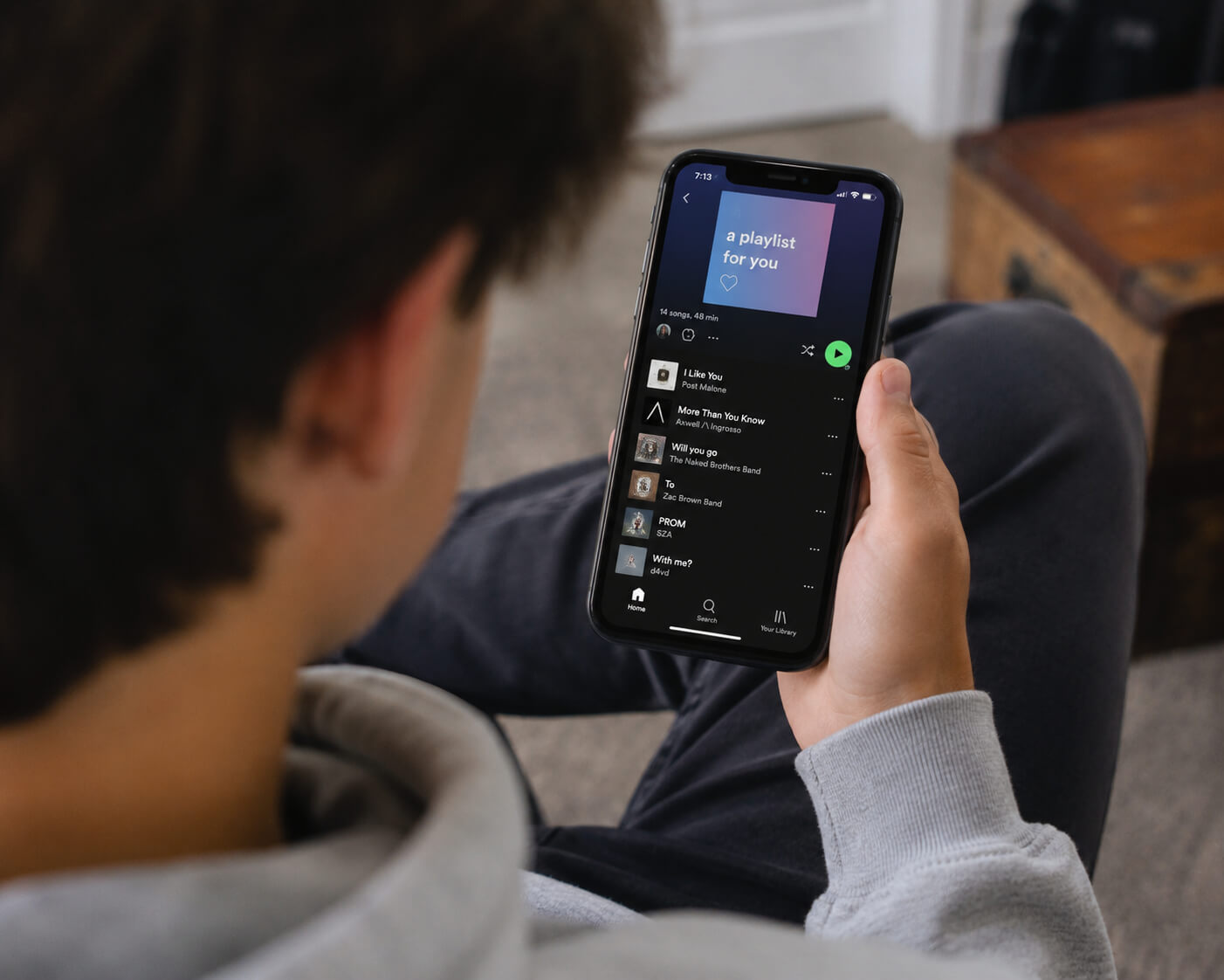 A-teenager-holding-a-smartphone-displaying-a-creative-custom-Spotify-music-playlist.