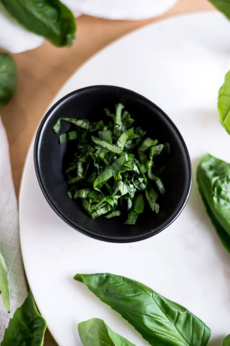 Image-of-torn-basil-in-a-small-bowl-for-cucumber-caprese-salad