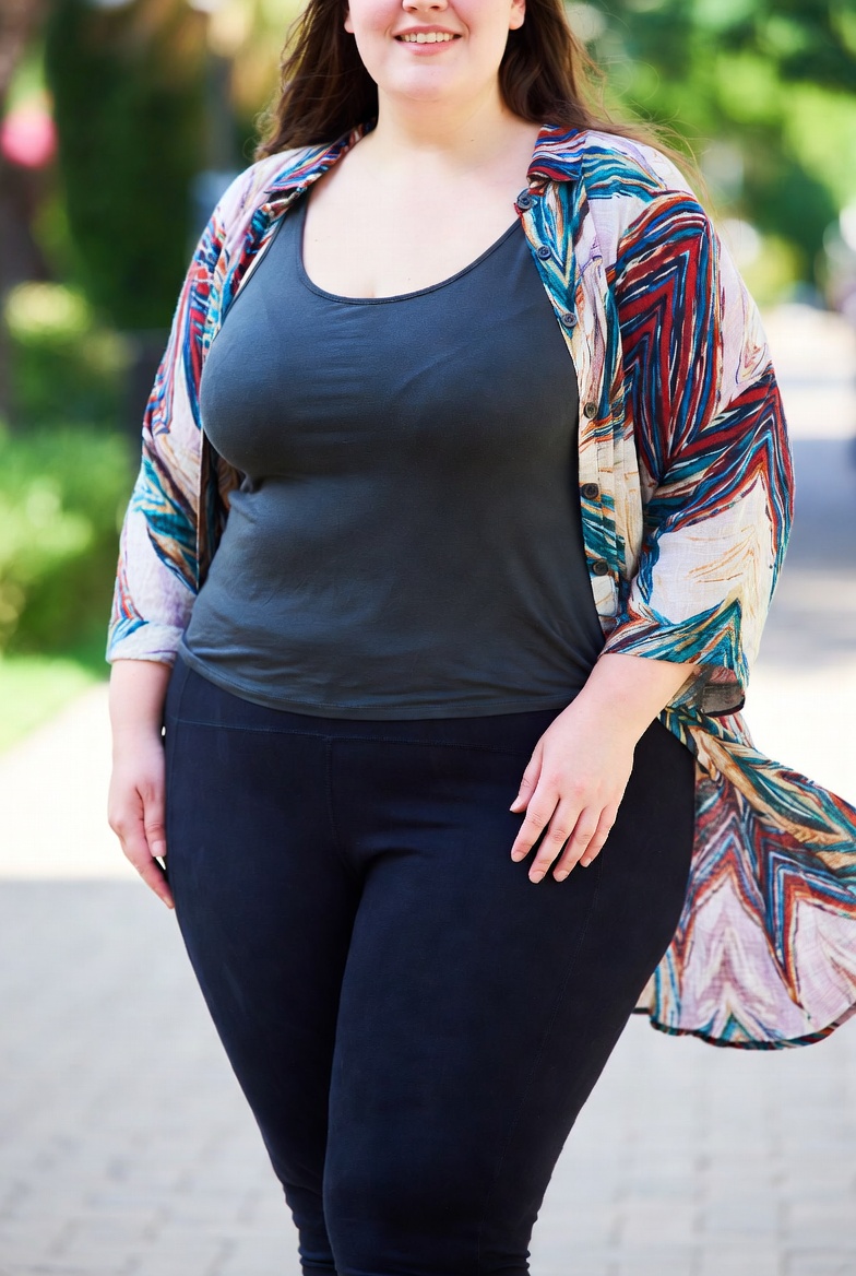 Curvy-woman-wearing-black-leggings-a-tank-top-and-an-open-linen-shirt